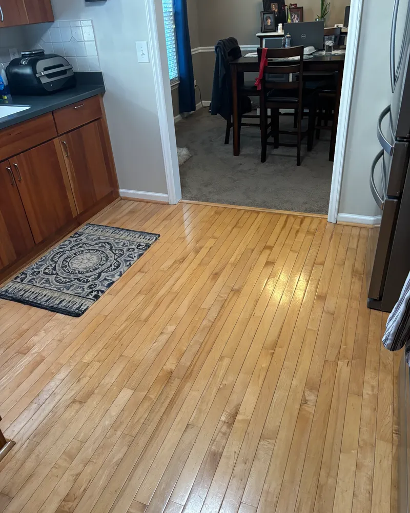 Kitchen with worn, shiny wood floors and carpeted dining room before installation