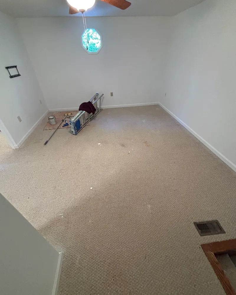 Bonus room with worn beige carpet before installation