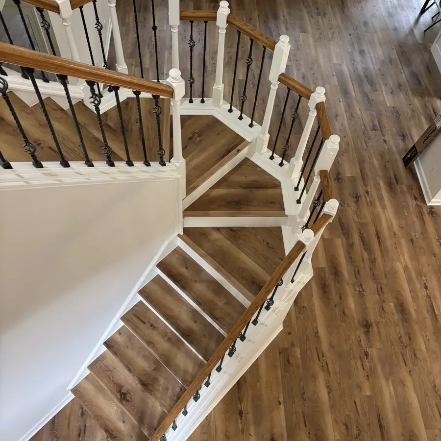 Staircase finished with LVP treads and matching floors by Barefoot Floors
